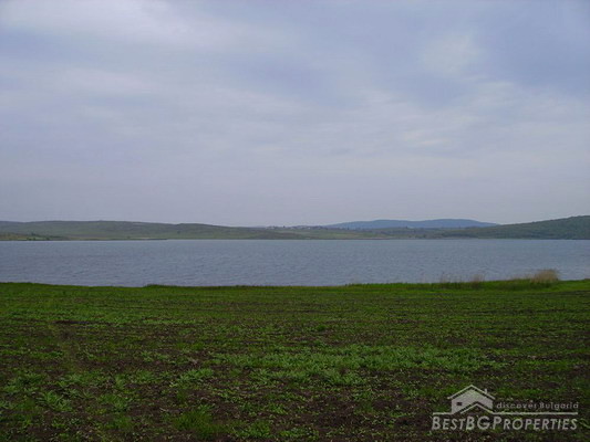 La trama grande di lago vicino agricolo di terra
