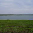 La trama grande di lago vicino agricolo di terra